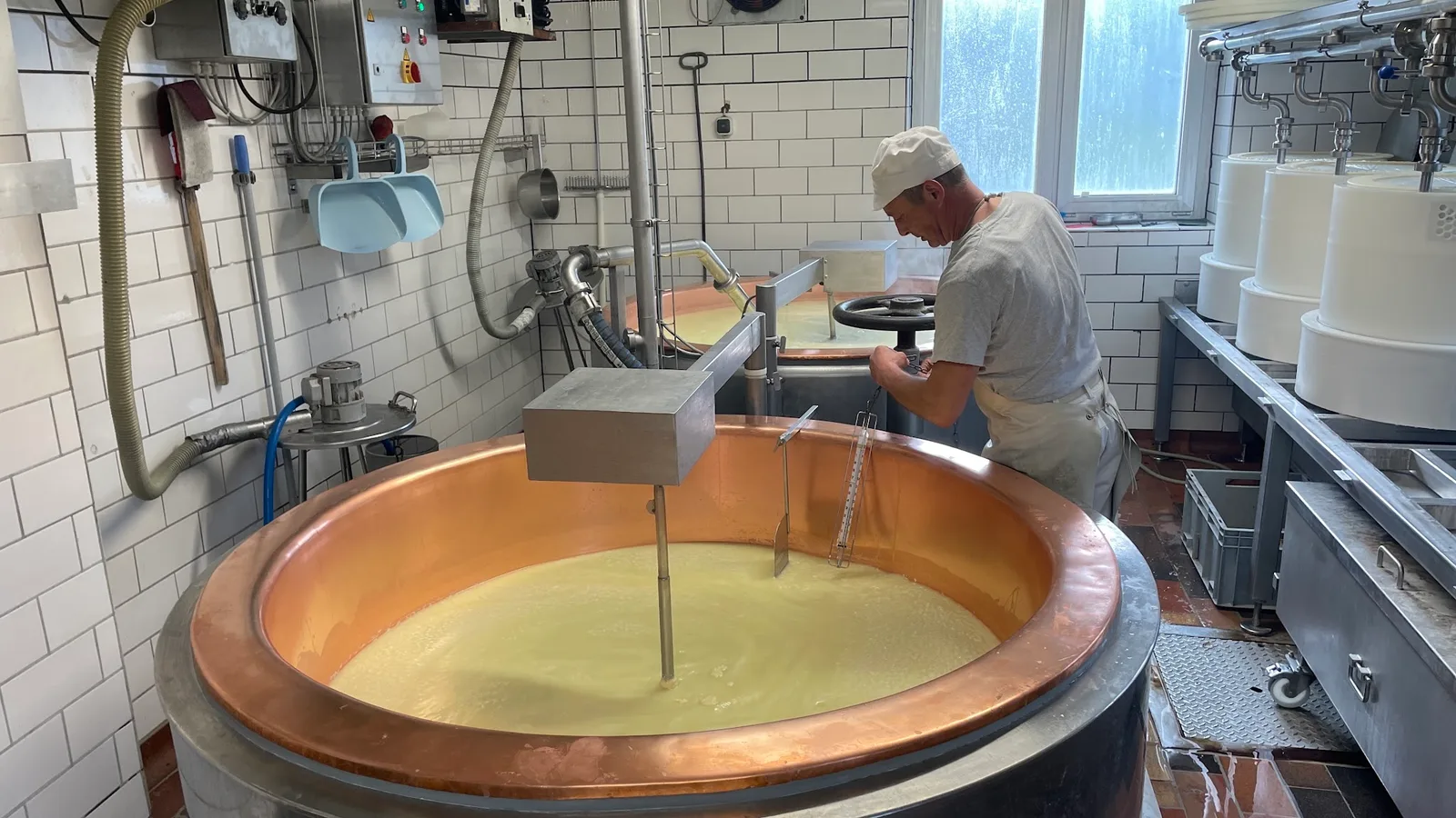 Senner bei der Arbeit am Kupferkessel in der Käseküche